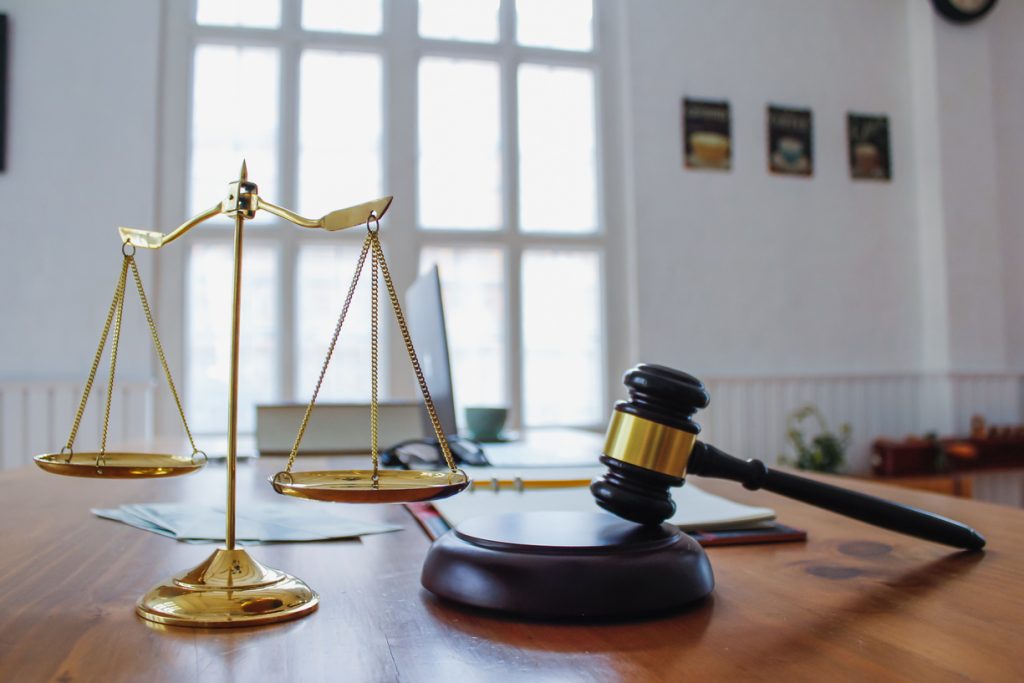 The mallet and brass scales are placed on the table in the lawyer's office for decorative purposes and are a symbol of justice in court decisions.