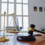 The mallet and brass scales are placed on the table in the lawyer's office for decorative purposes and are a symbol of justice in court decisions.